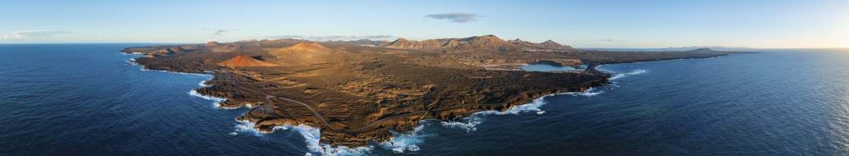Coast with lava fields, volcanic landscape near Los Hervideros with red volcano Montaña Bermeja, in