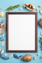 Composition with wooden frame, seashells, green boxwood. mockup on blue pastel background. Blank,