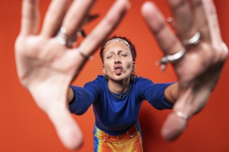 A fashionable woman stands out in vibrant trousers, playfully making a fish face. She showcases