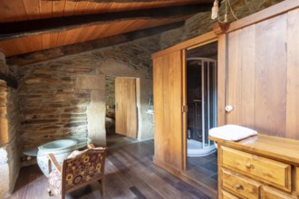 Picture of a charming rustic room inside a country house located in Lugo, Spain, featuring a stone