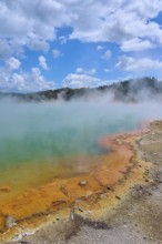 A hot spring with colourful rim and rising steam, Champagne Pool thermal lake, Wai-O-Tapu Thermal