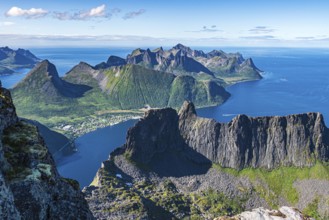 Aerial view from top of Mt. Grytetippen towards village Fjordgard, Mt. Segla and Mt. Hesten, Senja
