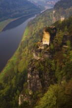 The bright lit Wartturm above the Elbe river seen from the Bastei rocks near the village of Rathen