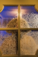 Frost-covered window with a blurred figure seen through the glass, capturing the essence of a cold
