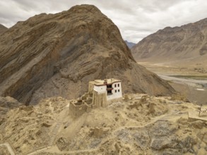 A solitary monastery nestled in the rugged mountains of the Zanskar Valley, Ladakh, India, captures