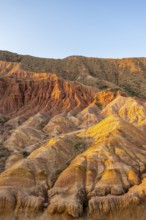 Erosion landscape of red and yellow sandstone, rock formations at sunrise, Skazka Canyon, fairytale