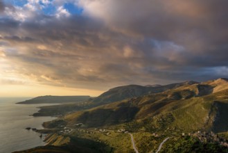 Golden hour view of the rugged hills and coastal villages of the Mani Peninsula, with winding roads
