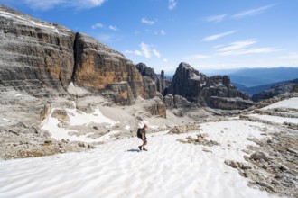 Mountaineers in a snowfield on the Sella della Tosa, mountain landscape with steep cliffs, Brenta