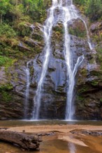 Waterfall over moss-covered rocks and tropical forest vegetation in the state of Minas Gerais,