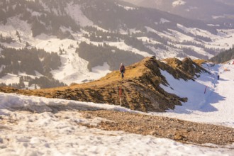 Landscape with snow-covered mountains and a narrow hiking trail that snakes through the winter