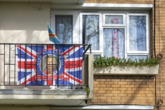 Patriotic Union Jack flag featuring King Charles on balcony of flat, Sydenham, Lewisham, London,