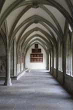Perspective interior view of a historic Gothic cloister with cross-ribbed vaulting, ogival windows