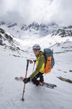 Skier skiing down a steep slope, Piz Laviner, view of mountain panorama in wintry mountain