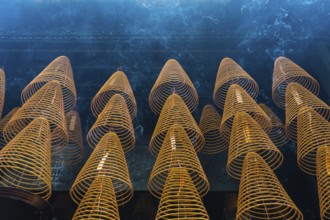 Numerous large, spiral incense coils hanging in a Taoist and Chinese Buddhist temple in Macau,