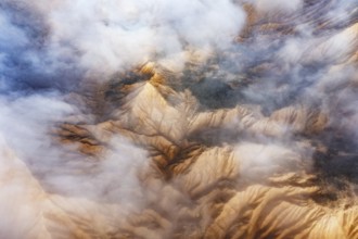 Stunning aerial view of rocky mountain peaks partially obscured by white clouds The landscape