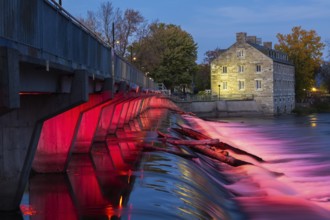 Illuminated Moulin Neuf water flow control dam and walkway over Des Mille-Iles river plus New Mill