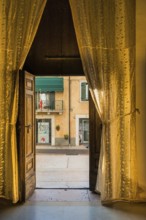 View from a room through curtains onto the street, Lazise, Italy