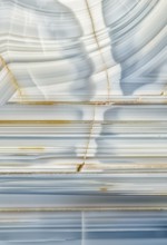 A macro photograph showcasing the striking linear patterns and mineral details inside a Whitcomb