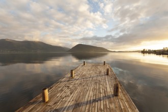 Golden hour light over the harbor and mountains. Summer sunset, Rosendal Port, Vestland, Norway