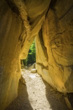 Incidental sun illuminates the passage (Chambre du Roi) through the high rocks, hike through the