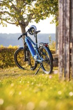 A bicycle with helmet standing next to a tree in a rural area, e-bike, forest bike, Calw, district