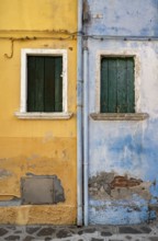 Blue and yellow house facade with windows, colourful houses on the island of Burano, Venice,