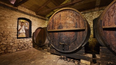 Wooden barrels in a historic wine cellar with painted wall decoration, Achaia Clauss winery,