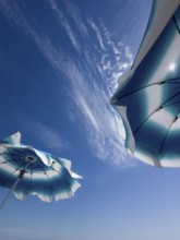 Parasols in front of a blue sky with clouds