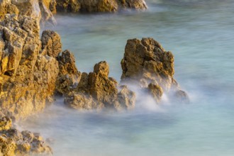 Crystal clear and turquoise water on the beach of Ustrine Bay on a sunny day at sunset on the
