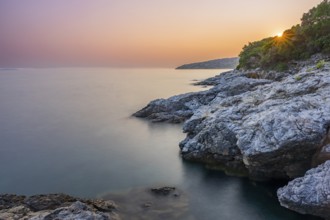 Crystal clear and turquoise water on the beach of Ustrine Bay on a sunny day at sunset on the