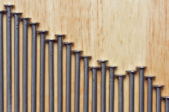 Declining Graph of Nails on a Wood Background