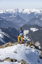 View of the Inn Valley, mountaineer at the summit of the Pirchkogel, mountains in winter,