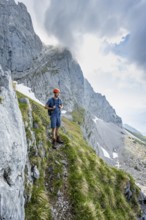 Mountaineer with helmet on a narrow hiking trail, ascent to the Ackerlspitze, Wilder Kaiser, Kaiser