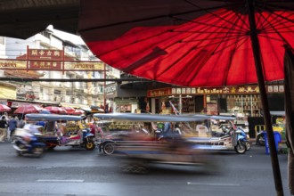 Bangkok, Thailand. March 25th 2025. Busy evening traffic of tuk-tuk and taxis passing popular