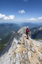Mountaineer with helmet on a mountain ridge, ascent to the Zugspitze, Zugspitze via ferrata,