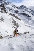 Mountaineer with skis at the fork Porta d'Es-cha, ski tour Bündner Haute Route, Albula Alps,