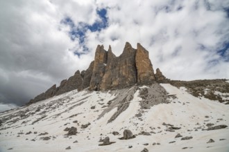 The majestic peaks of Tre cime di Lavaredo rise against a dramatic sky in the Dolomites mountains,