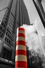 Steaming chimney at a construction site behind a skyscraper, New York City, USA