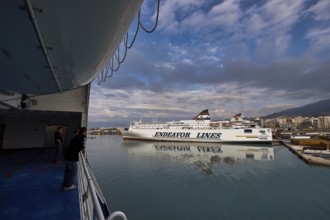 View from a ferry of the harbor with ships and dramatic clouds, Old ferry port in central Patras,
