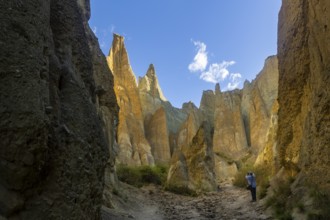 Back view of unrecognizable person exploring the dramatic Clay Cliffs in the Canterbury region of