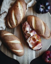Freshly baked olive oil bread topped with slices of serrano ham and ripe tomatoes on a rustic
