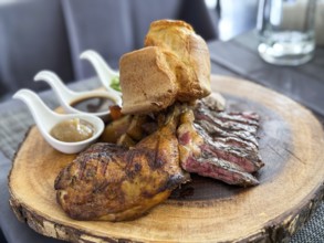 A succulent plate of steak slices and roasted chicken leg served with Yorkshire pudding and a trio