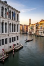 View of the Grand Canal with gondoliers at sunset, picturesque evening mood with palazzos on the