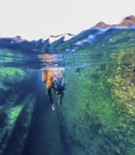 A female swimmer explores the clear natural pools of Tindaya Beach in Fuerteventura, Canary