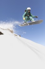 A snowboarder expertly navigates a thrilling freeride descent, capturing the essence of extreme