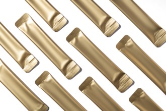 Top view of multiple golden collagen jelly sachets neatly arranged on a white background. These