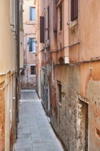 View from a bridge into a small street 'Calle del forno' in Venice on a sunny day in winter, Italy