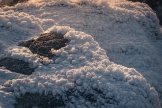 Closeup of snow covered rocks in the Siete Picos, Sierra de Guadarrama, Madrid. The winter sun