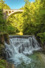 Stunning waterfall cascading beneath a stone bridge in the picturesque vintgar gorge near bled,