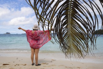 A woman enjoys the breathtaking panorama of the Raja Ampat Archipelago in West Papua, Indonesia The